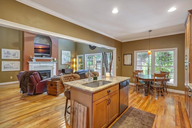 kitchen featuring a fireplace, hanging light fixtures, stainless steel dishwasher, light stone countertops, and crown molding