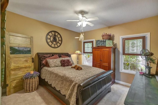 bedroom featuring a ceiling fan, light colored carpet, and baseboards