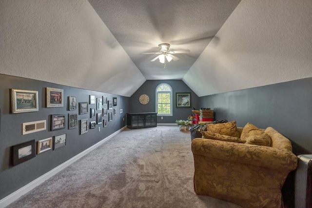 interior space with baseboards, lofted ceiling, ceiling fan, carpet, and a textured ceiling