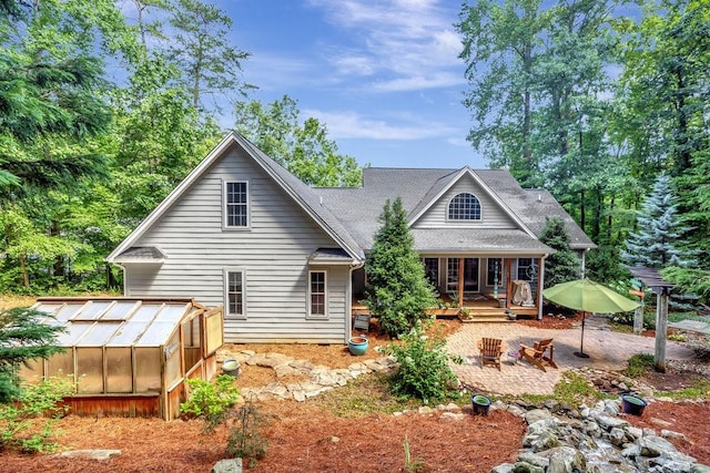 rear view of property with an outbuilding, an exterior structure, and a patio