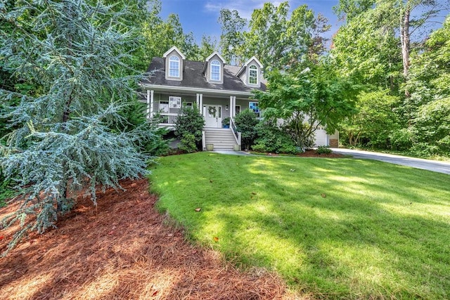 cape cod-style house featuring a garage, covered porch, and a front yard