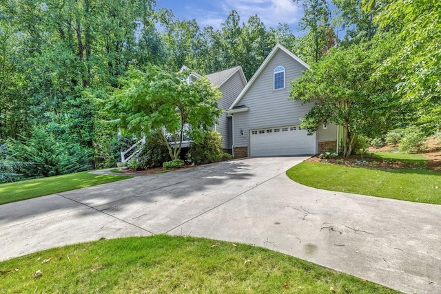 obstructed view of property with concrete driveway, brick siding, and a front yard