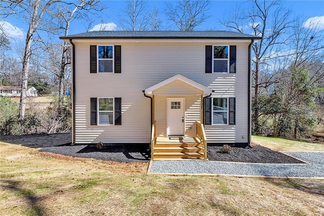 colonial-style house featuring a front lawn