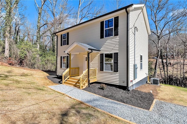 colonial house featuring a front lawn and central AC unit