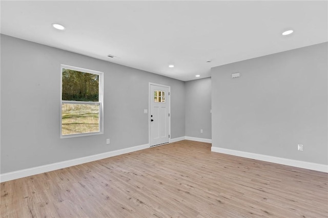 spare room featuring light wood finished floors, recessed lighting, and baseboards