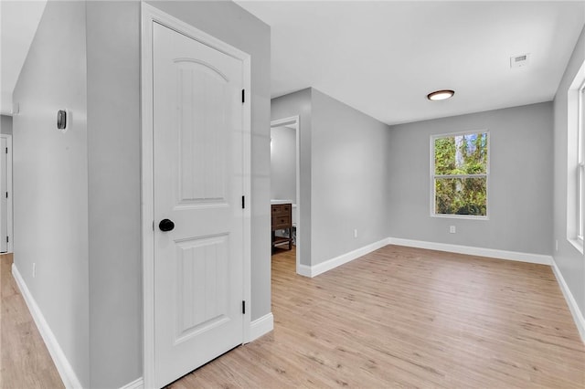 interior space with visible vents, light wood-style flooring, and baseboards