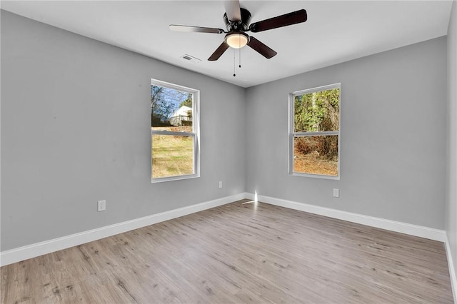 empty room featuring a healthy amount of sunlight, baseboards, and visible vents