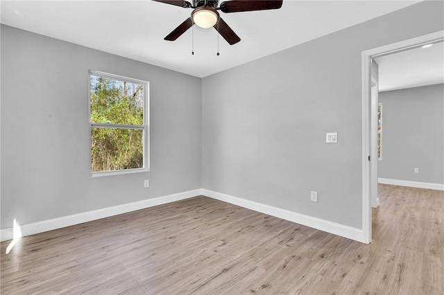 empty room with light wood finished floors, ceiling fan, and baseboards