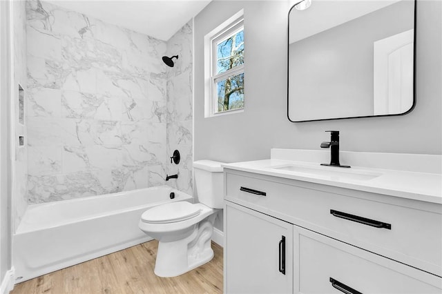 bathroom featuring toilet, bathing tub / shower combination, wood finished floors, and vanity