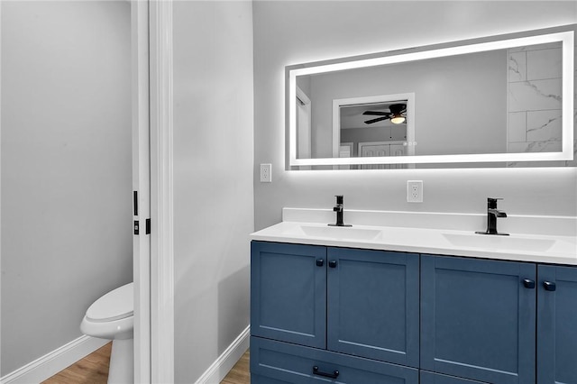 full bath with double vanity, wood finished floors, and a sink