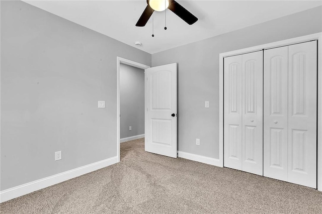 unfurnished bedroom with carpet floors, a closet, ceiling fan, and baseboards