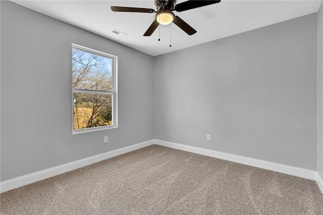 spare room with carpet, visible vents, and baseboards