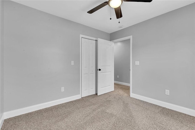 unfurnished bedroom featuring light carpet, a closet, a ceiling fan, and baseboards