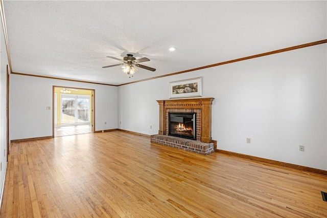 unfurnished living room with a ceiling fan, light wood-type flooring, a fireplace, and baseboards