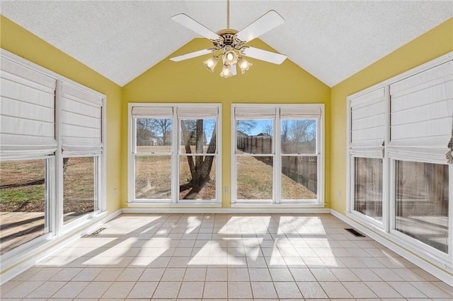 unfurnished sunroom featuring ceiling fan, plenty of natural light, visible vents, and vaulted ceiling