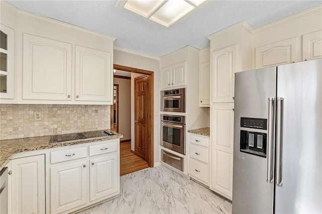 kitchen with a warming drawer, appliances with stainless steel finishes, stone countertops, glass insert cabinets, and white cabinets