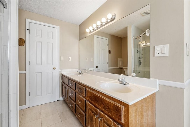 full bath featuring a textured ceiling, tile patterned flooring, a sink, double vanity, and a stall shower