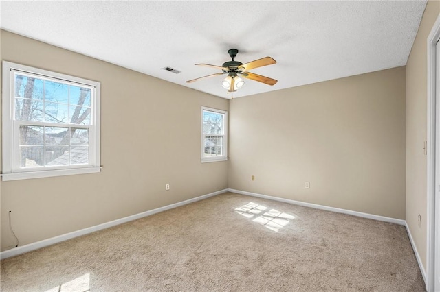 unfurnished room featuring light colored carpet, visible vents, a textured ceiling, and baseboards