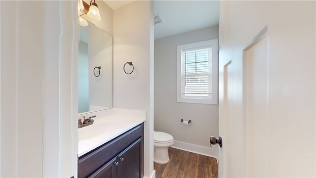 bathroom with baseboards, vanity, toilet, and wood finished floors