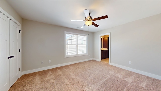 unfurnished bedroom with light carpet, a closet, visible vents, and baseboards