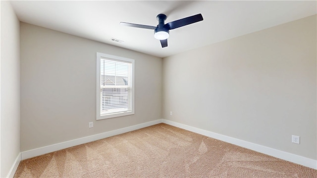 empty room with a ceiling fan, carpet flooring, visible vents, and baseboards