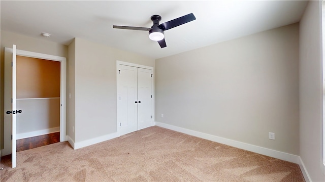 unfurnished bedroom featuring carpet floors, a closet, a ceiling fan, and baseboards