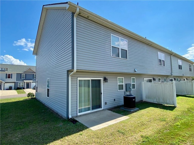 back of house featuring central AC, a yard, and a patio