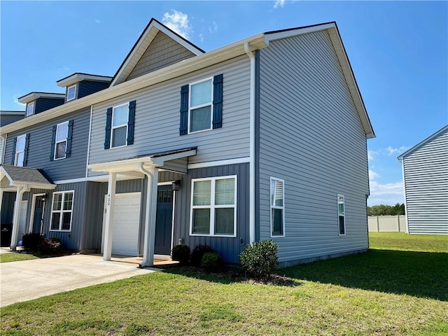 view of front of home featuring board and batten siding, a garage, driveway, and a front lawn