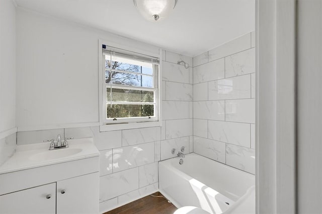 bathroom with  shower combination, wood finished floors, vanity, and tile walls