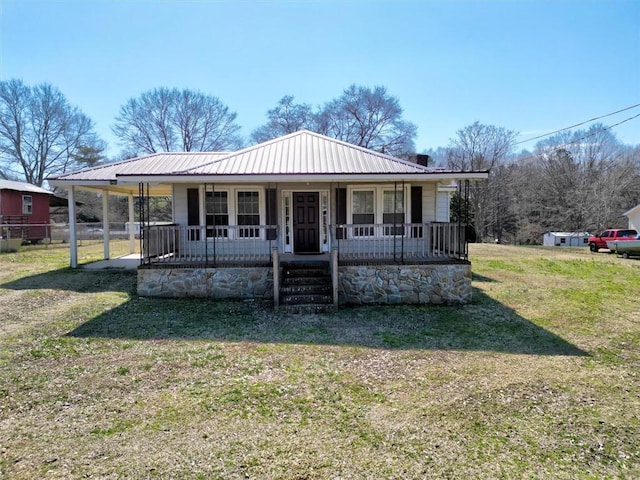 bungalow-style home with covered porch, metal roof, and a front yard