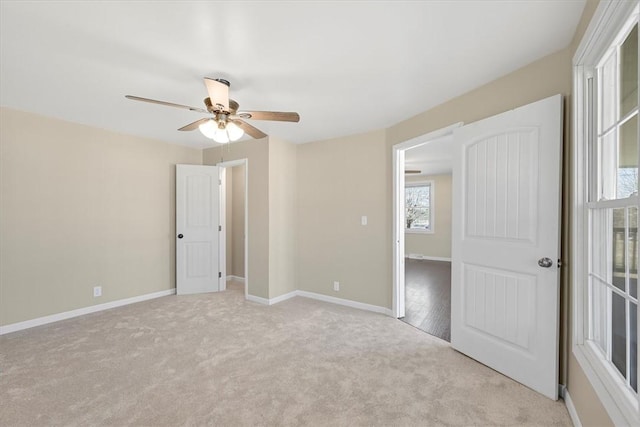 unfurnished bedroom with light carpet, baseboards, and a ceiling fan