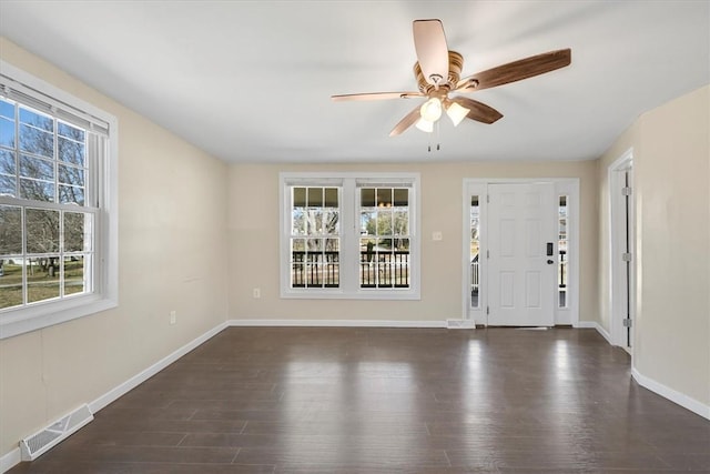 entrance foyer with dark wood-type flooring, a ceiling fan, visible vents, and baseboards