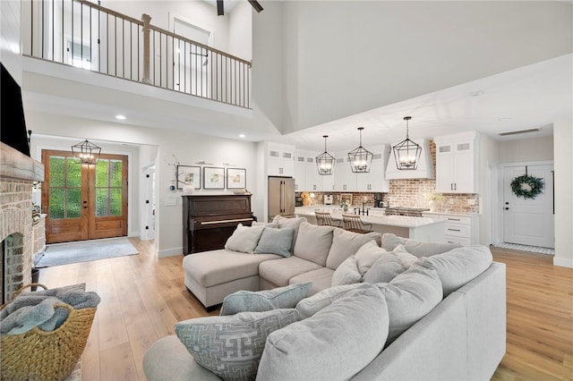 living room with baseboards, a fireplace, visible vents, and light wood-style floors