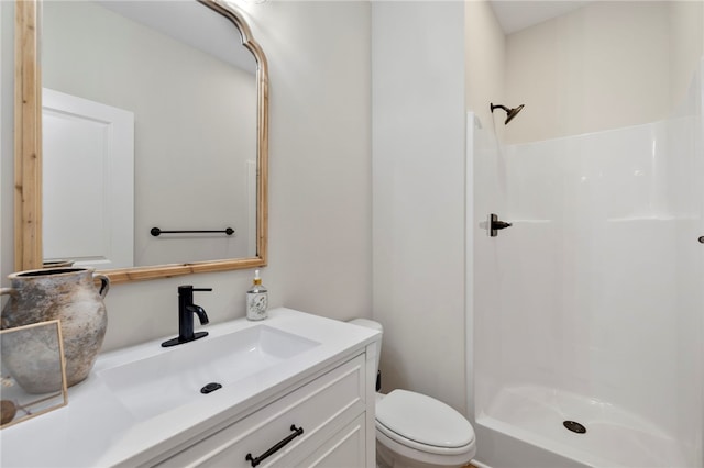 bathroom featuring vanity, toilet, and a shower stall