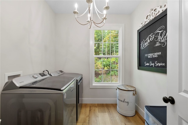 washroom with a notable chandelier, light wood-style floors, washing machine and dryer, laundry area, and baseboards