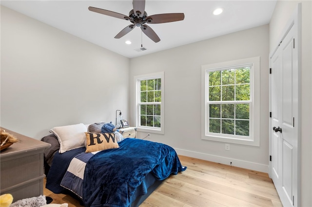 bedroom with recessed lighting, multiple windows, light wood-style flooring, and baseboards