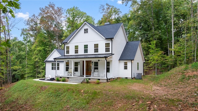 modern farmhouse style home featuring a standing seam roof, metal roof, covered porch, crawl space, and a chimney