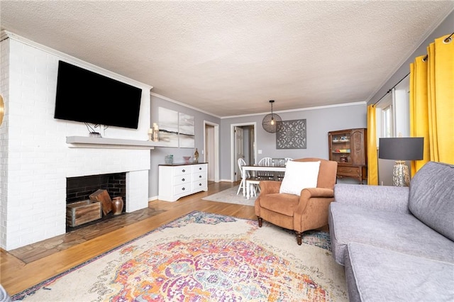 living room with a textured ceiling, a fireplace, and wood finished floors