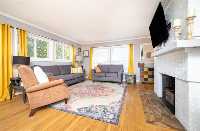 living area with baseboards, a brick fireplace, wood finished floors, and crown molding