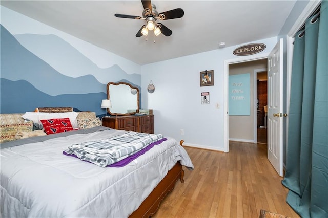 bedroom with a ceiling fan, baseboards, and wood finished floors