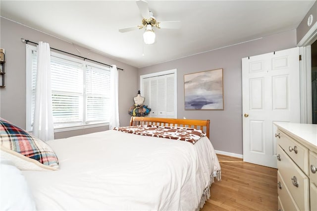 bedroom featuring a closet, baseboards, a ceiling fan, and light wood finished floors