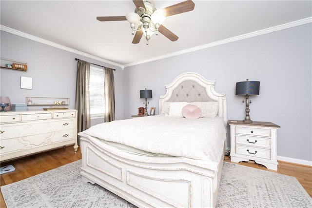 bedroom featuring baseboards, a ceiling fan, wood finished floors, and crown molding