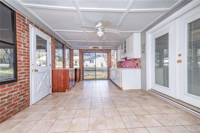 unfurnished sunroom featuring a ceiling fan