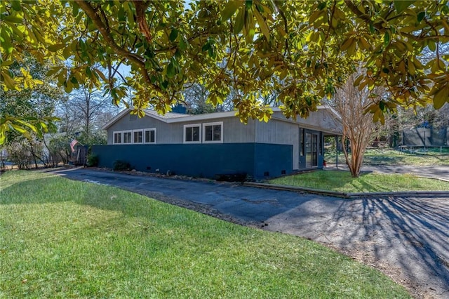 ranch-style home with driveway and a front lawn