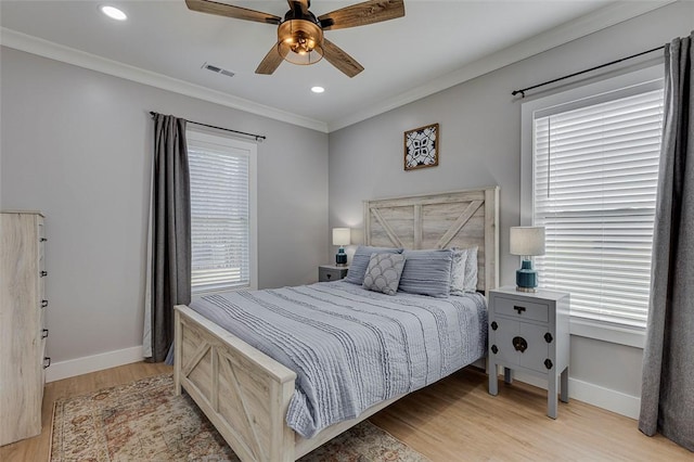 bedroom featuring baseboards, recessed lighting, light wood-type flooring, and crown molding