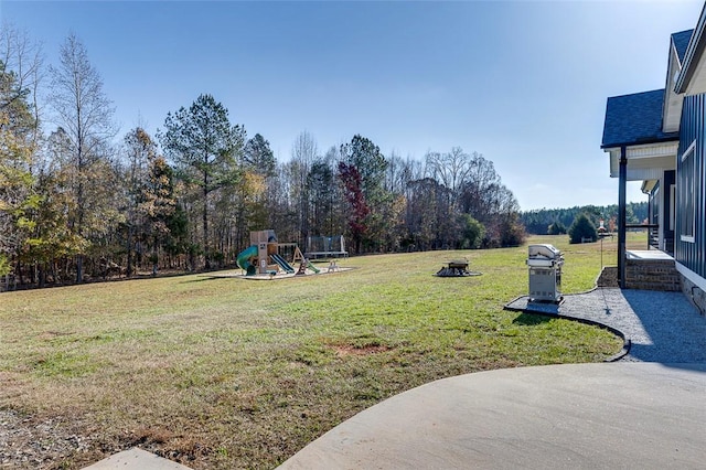 view of yard with a patio area, a playground, and a fire pit