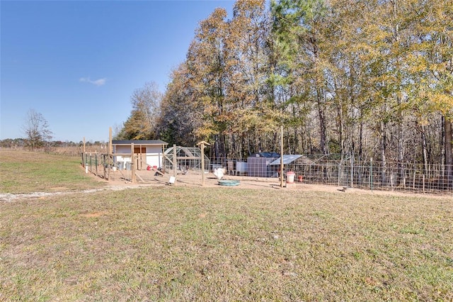 view of yard with an outbuilding, fence, and exterior structure