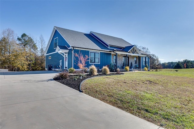 view of front of home featuring driveway, a front lawn, and board and batten siding