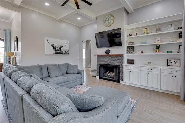 living room featuring light wood-style flooring, coffered ceiling, ornamental molding, a brick fireplace, and beamed ceiling