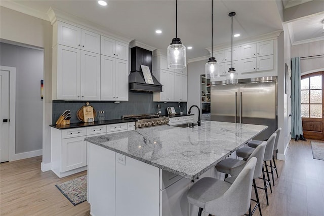 kitchen featuring custom range hood, ornamental molding, backsplash, and a sink